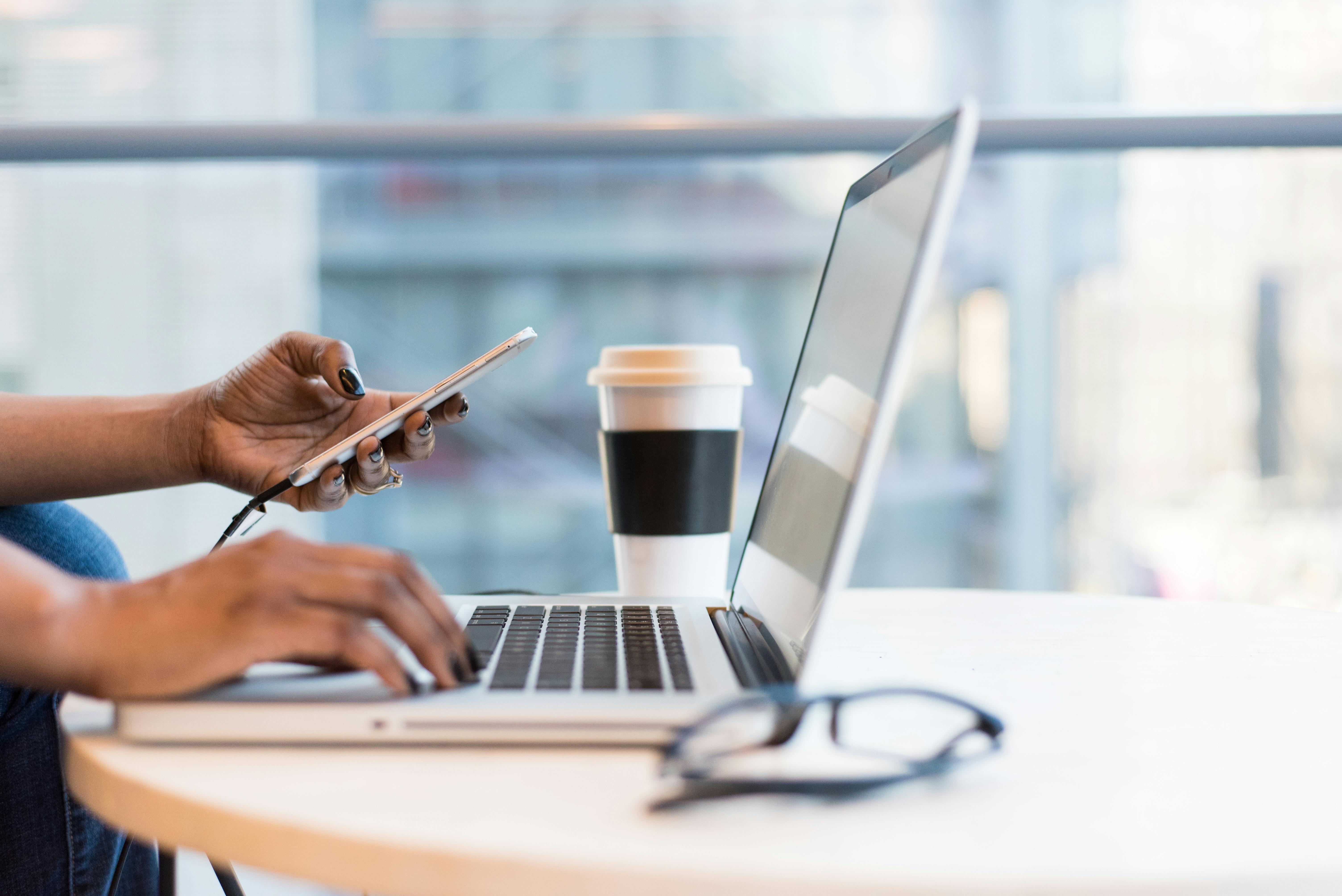 Woman working on laptop and smartphone 